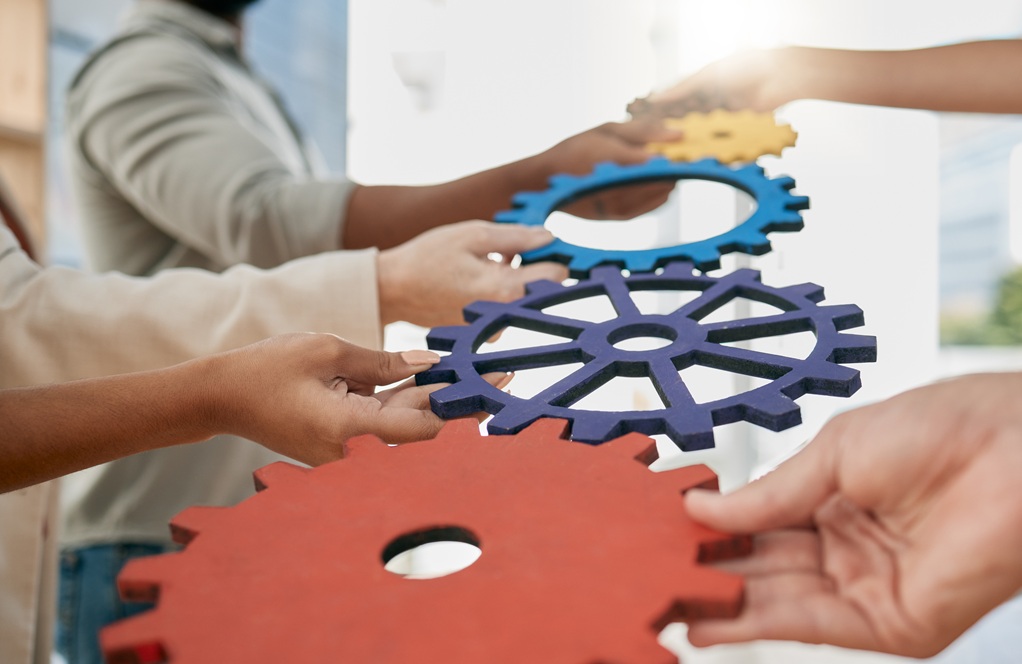 Business people, toys and gears at job for teamwork, sign or symbol with solution, trust and solida.